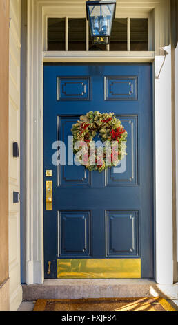 Une couronne ou une guirlande de Noël accrochée à une porte d'entrée bleue dans le quartier de Beacon Hill à Boston, Boston, Massachusetts, États-Unis Banque D'Images