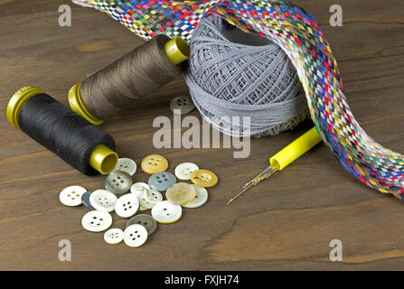 Une collection d'outils et fournitures de couture isolé sur un fond de bois. Banque D'Images