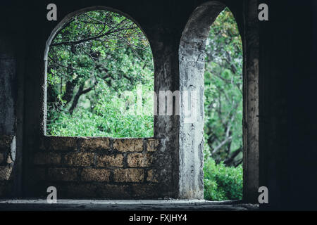 Ouvertures en plein cintre d'une vieille maison avec vue sur le jardin Banque D'Images