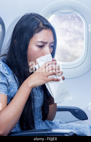 Femme dans l'avion a vomi dans un sac en papier Banque D'Images