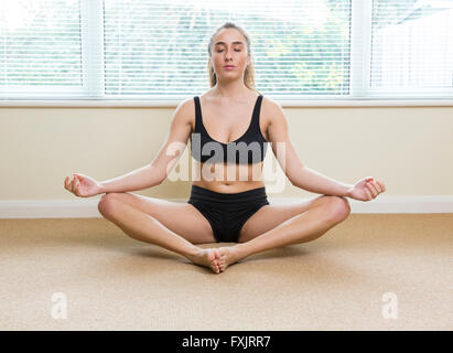 Jeune femme en lotus yoga pose Banque D'Images