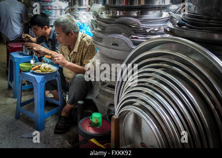 Les habitants de manger le déjeuner à l'intérieur du marché Binh Tay, Ho Chi Minh City, Vietnam Banque D'Images