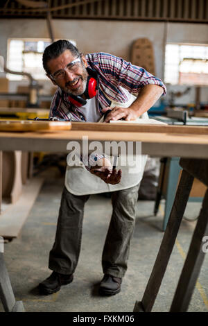 Menuisier travaillant sur planche en bois à l'établi Banque D'Images