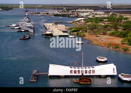 22 juin 1998 - Pearl Harbor, Hawaii, United States of America - remorqueurs pousser le cuirassé USS Missouri (BB 63) pour son nouveau poste de mouillage à l'île de Ford, le 22 juin 1998, tel qu'il se joint à l'USS Arizona Memorial (premier plan) dans la région de Pearl Harbor, Hawaii. United States Secrétaire de la marine John H. Dalton a signé l'accord de don, le 4 mai, permettant à Washington d'être utilisé comme un musée près de l'Arizona Memorial comme symboles du début et de la fin de la Seconde Guerre mondiale. Le Missouri a été remorqué jusqu'à 2 600 miles à travers l'océan Pacifique de Bremerton, Washington. Crédit obligatoire : Kerry E. Baker/U.S. Banque D'Images