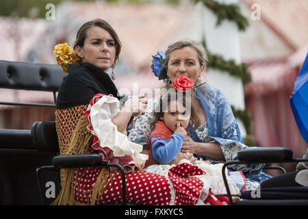 Séville, Espagne. Apr 16, 2016. Les femmes et une jeune fille habillée d'une robe flamenco typique balade en char à la ''Feria de Abril'' (avril 2016) du salon © Daniel Gonzalez Acuna/ZUMA/Alamy Fil Live News Banque D'Images