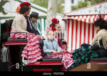 Séville, Espagne. Apr 16, 2016. Les femmes et une jeune fille habillée d'une robe flamenco typique balade en char à la ''Feria de Abril'' (avril 2016) du salon © Daniel Gonzalez Acuna/ZUMA/Alamy Fil Live News Banque D'Images