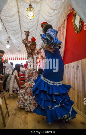 Séville, Espagne. Apr 16, 2016. Deux femmes vêtues de robe flamenco dance traditionnel ''sevillanas'' dans un stand lors de la foire ''Feria de Abril'' (avril 2016) du salon © Daniel Gonzalez Acuna/ZUMA/Alamy Fil Live News Banque D'Images