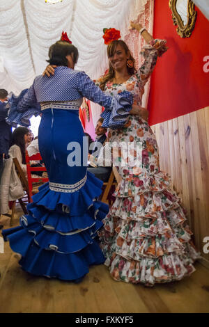 Séville, Espagne. Apr 16, 2016. Deux femmes vêtues de robe flamenco dance traditionnel ''sevillanas'' dans un stand lors de la foire ''Feria de Abril'' (avril 2016) du salon © Daniel Gonzalez Acuna/ZUMA/Alamy Fil Live News Banque D'Images