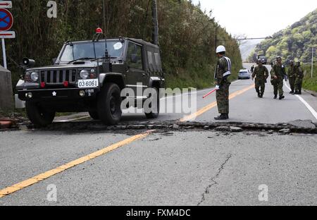 Kumamoto, dans le sud-ouest de la préfecture de Kumamoto au Japon. 17 avr, 2016. Un véhicule militaire a passé des disques durs endommagés dans Minami-Aso la route dans le sud-ouest de la préfecture de Kumamoto, Japon, le 17 avril 2016. Un puissant séisme de magnitude-7.3 l'île de Kyushu dans le sud-ouest de Japon tôt samedi un jour seulement après une importante foreshock a frappé la région, avec le nombre de décès est actuellement de 41 selon les derniers chiffres, le dimanche. Credit : Liu Tian/Xinhua/Alamy Live News Banque D'Images