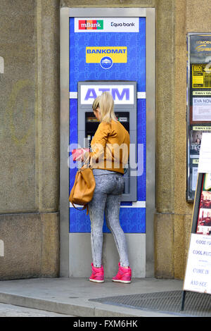 Prague, République tchèque. Woman getting l'argent d'un distributeur automatique de billets Bankomat Banque D'Images