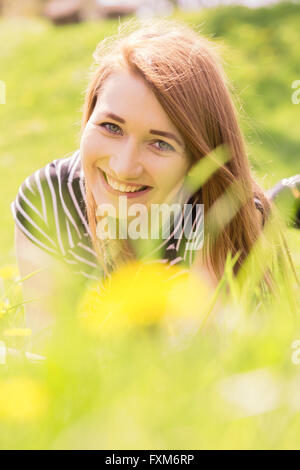 Happy red hair girl lying in grass Banque D'Images