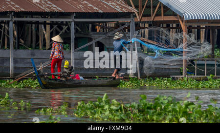 La pêche traditionnelle, les gens jetaient un filet d'un bateau en vêtements traditionnels, Chau Doc, Vietnam Banque D'Images