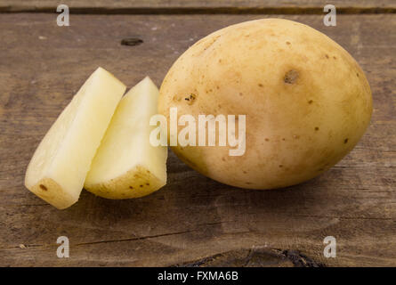 La photo en gros plan de tranches de pommes de terre et sur la table de bois rustique Banque D'Images