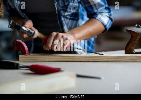 Female Carpenter à l'aide d'un burin sur planche en bois Banque D'Images
