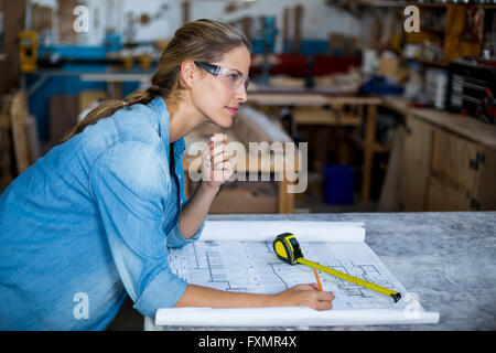 Female carpenter marquage sur plan Banque D'Images