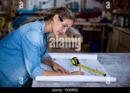 Female carpenter marquage sur plan Banque D'Images