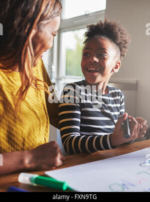 Heureux l'enfant l'apprentissage de l'alphabet avec sa mère, femme et enfant noir Banque D'Images