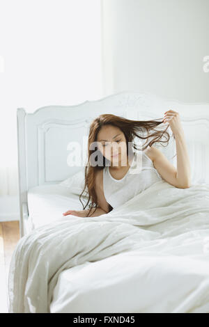 Belle jeune femme au lit japonais Banque D'Images