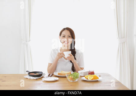Jeune femme japonaise attrayant le petit-déjeuner à l'accueil Banque D'Images