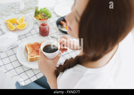 Jeune femme japonaise attrayant le petit-déjeuner à l'accueil Banque D'Images