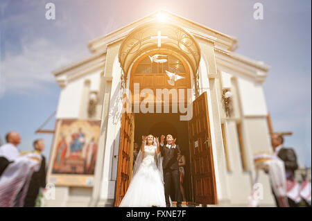 Paire de mains relâchant des colombes blanches wedding couple pendant le coucher du soleil Banque D'Images