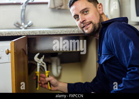 Portrait d'un plumber repairing sink Banque D'Images