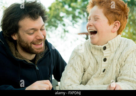 Père et fils rire ensemble à l'extérieur Banque D'Images