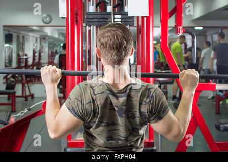 L'homme musclé effectuant lat pulldown dans la salle de sport Banque D'Images