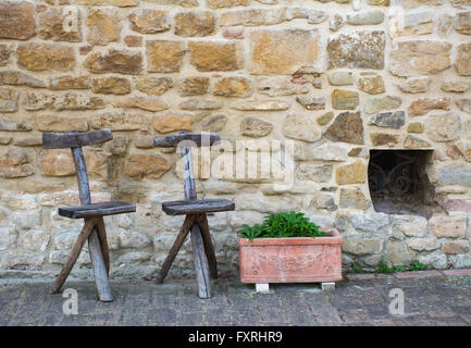 Deux vieilles chaises typiques de la toscane et à côté d'un pot en argile et une petite fenêtre. Banque D'Images