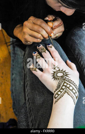 Une femme s'applique un Indien tatouage au henné pour a woman's hand. Banque D'Images