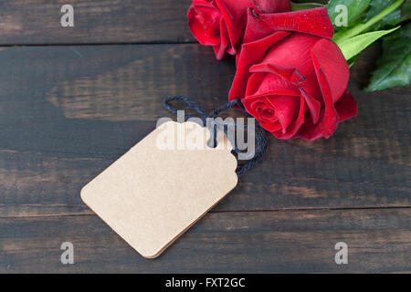 Roses rouges avec gift tag sur table en bois rustique avec copie espace. Profondeur de champ Banque D'Images