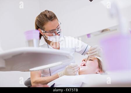 Clinique dentaire dentiste dans la conduite de l'examen dentaire sur la jeune femme Banque D'Images