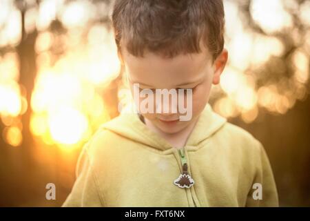 Portrait of boy wearing hooded top looking down Banque D'Images