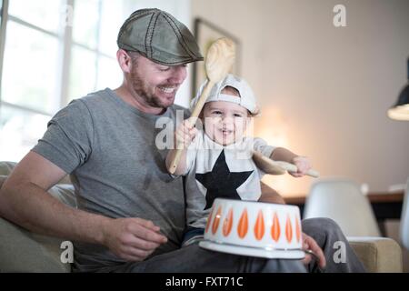 Baby Boy sur les pères tour à jouer de la batterie sur l'envers casserole Banque D'Images