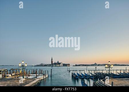 Vue éloignée de lignes de front sur les gondoles amarrées au crépuscule, Venise, Italie Banque D'Images