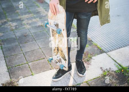 Taille en bas voir de jeunes urbains hommes debout sur la planche trottoir Banque D'Images