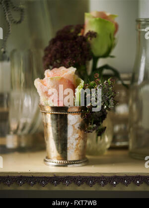 Vintage silver tumbler avec rose rose sur la tablette Banque D'Images