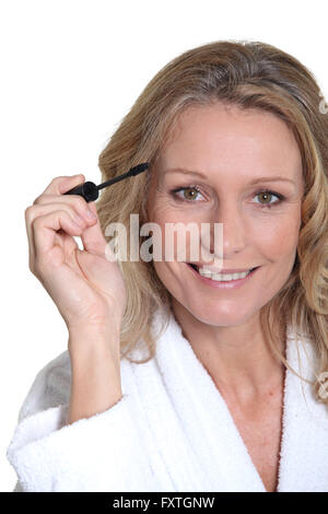 Woman putting mascara sur Banque D'Images