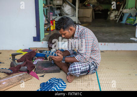 La fabrication des chaussures homme indien dans un atelier de fortune au bord de la route à Kuilapalayam, Auroville, Inde Banque D'Images