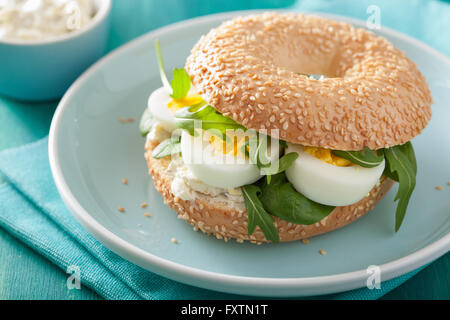 Le petit-déjeuner sandwich sur bagel avec fromage à la crème oeufs roquette Banque D'Images