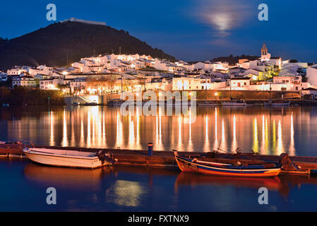 Le Portugal, l'Algarve : vue nocturne de l'espagnol riverside village San Lucar del Guadiana vu du port d'Alcoutim Banque D'Images