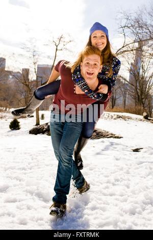 Young man giving girlfriend a piggy back in Central Park, New York, USA Banque D'Images