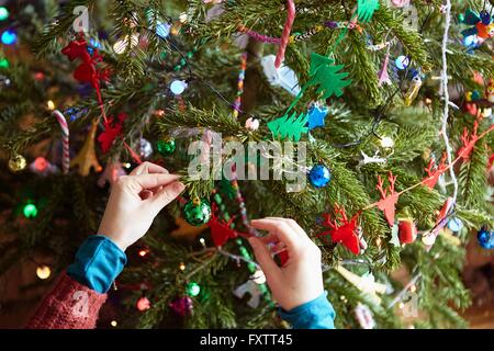 Les mains de womans préparer Noël décorations sur arbre de Noël Banque D'Images