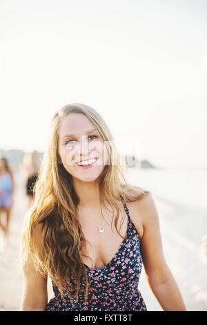 Portrait de jeune femme blonde aux cheveux longs à la caméra en souriant Banque D'Images