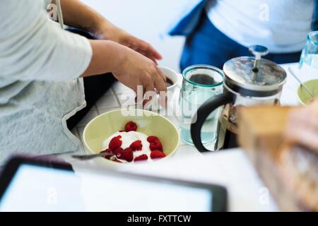Deux amies, dans la cuisine, ce qui fait du petit déjeuner, mid section Banque D'Images