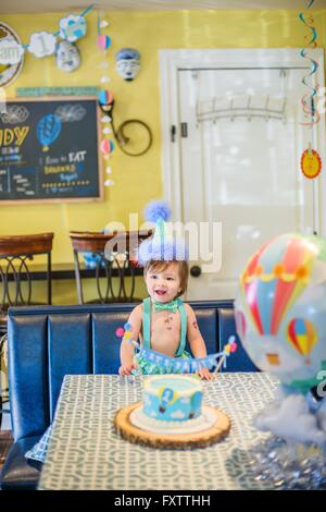 Baby Boy wearing party hat avec premier cake Banque D'Images