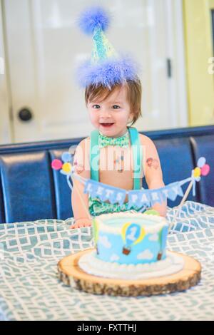 Baby Boy wearing party hat avec premier cake Banque D'Images