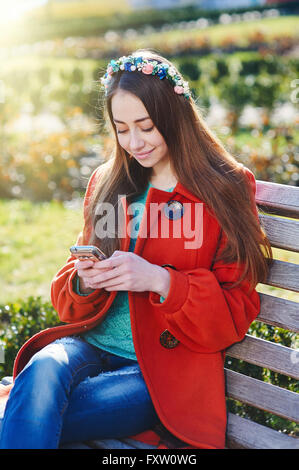 Beau Manteau femme assis sur un banc dans la ville Banque D'Images