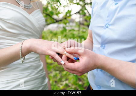 Robes de mariée marié une bague de mariage à son doigt Banque D'Images