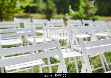 Chaises blanches en parc pour la cérémonie du mariage Banque D'Images